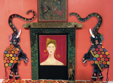 Colorful painted elephants on carved wood